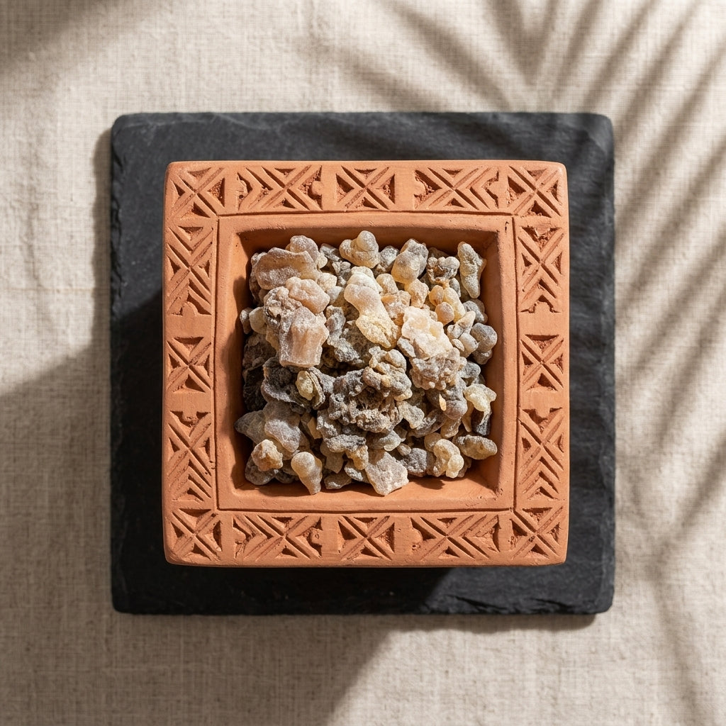 Terracotta dish with frankincense resin on a textured surface